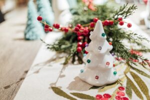 a table decorated with garland and a ceramic christmas tree