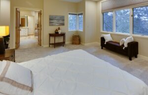 Photograph of a bedroom with an open door to an ensuite bathroom.