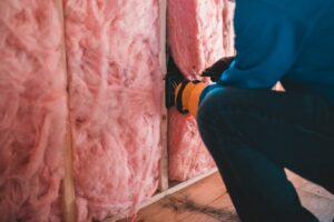 A worker installing insulation.