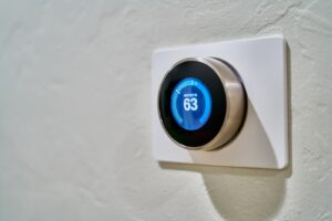 A photograph of a thermostat set to 63 degrees.