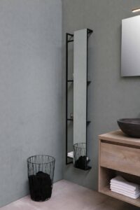 Photo of the corner of a bathroom with a full-length mirror and floating vanity.