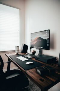 An image of a tidy wood desk with a monitor and slim keyboard.