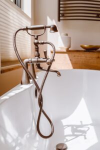 A photograph of a standalone bathtub with a vintage faucet.