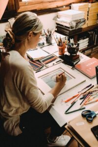 A photograph of a female artist painting a portrait.